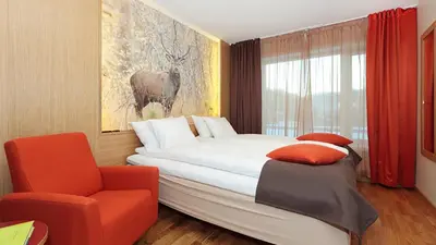 a hotel room with a bed and a chair at Frich`s Hotel Surnadal in Surnadal