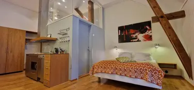 a bedroom with a bed and a kitchen in it at Vertshuset Røros in Røros