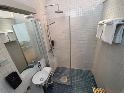 a bathroom with a shower and a toilet and a sink at Vertshuset Røros in Røros