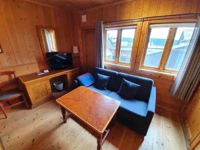 a living room with a blue couch and a table at Vertshuset Røros in Røros
