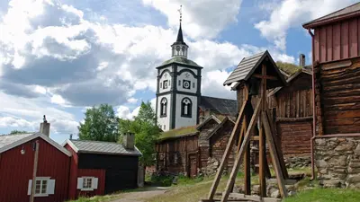 a church with a clock tower in a village at Vertshuset Røros in Røros