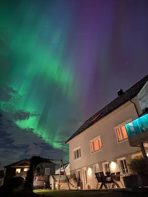 a house with the northern lights in the sky at Apartment Ulsteinvik in Ulsteinvik