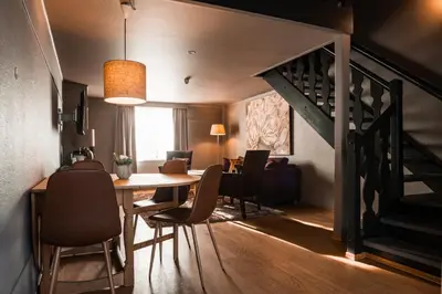 a dining room with a table and chairs and a staircase at Sundvolden Hotel in Sundvollen