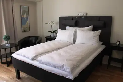 a large bed with white sheets and pillows at Støren Hotel in Storen