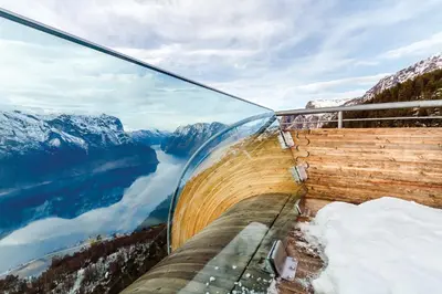 a glass building with a view of a lake and mountains at Vangsgaarden Gjestgiveri in Aurland
