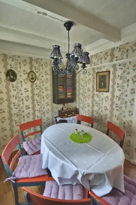 a dining room with a table and chairs and a chandelier at Vangsgaarden Gjestgiveri in Aurland