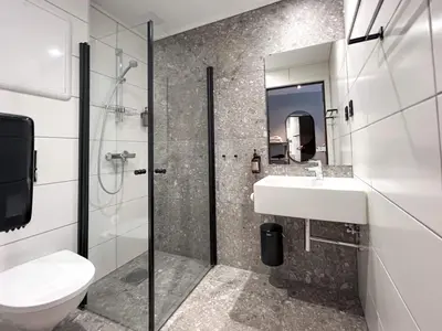 a bathroom with a sink and a toilet and a mirror at Trolltunga Hotel in Odda
