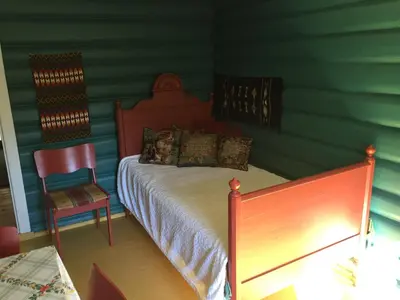 a bedroom with a bed and a chair in it at Løngdal in Tuddal