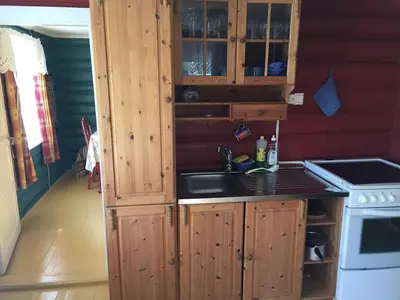a kitchen with wooden cabinets and a sink at Løngdal in Tuddal
