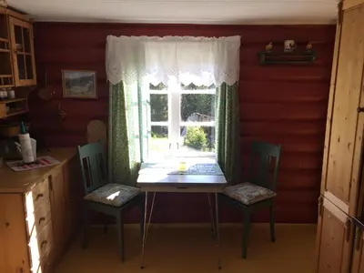 a table and chairs in a kitchen with a window at Løngdal in Tuddal