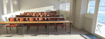 a conference room with a table and leather chairs at Voss Vandrarheim Hostel in Vossevangen