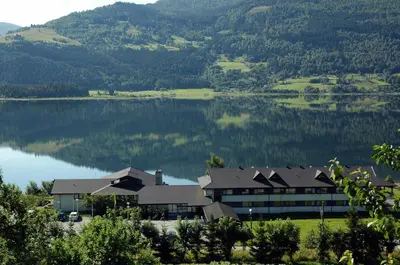 a building with a view of a lake and mountains at Voss Vandrarheim Hostel in Vossevangen