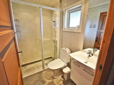 a bathroom with a shower and a toilet and a sink at Femundtunet in Drevsjø