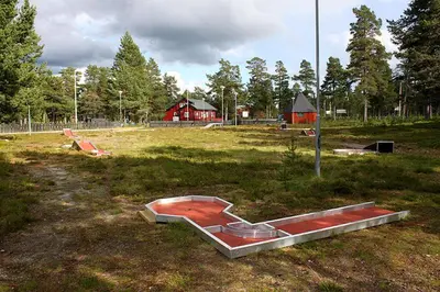 a park with a red playground with a red house at Femundtunet in Drevsjø
