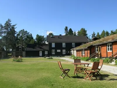 a picnic table and chairs in a yard with a building at Femundtunet in Drevsjø