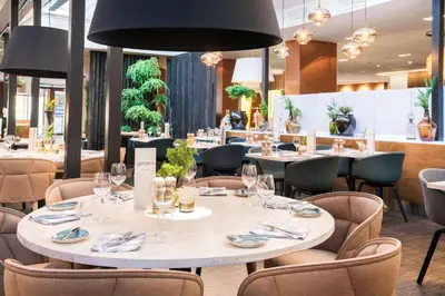 a dining room with tables and chairs and lights at Radisson Blu Royal Hotel, Bergen in Bergen