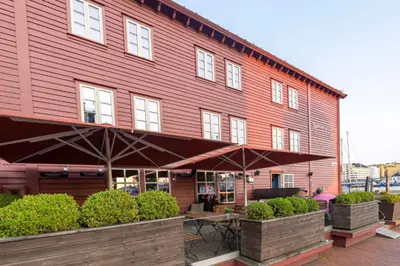 a red building with umbrellas in front of it at Radisson Blu Royal Hotel, Bergen in Bergen