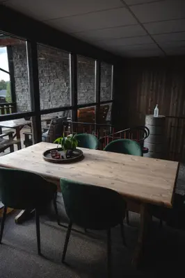 a wooden table with chairs and a plate on it at Trolltun Hotel & Hytter in Dombås