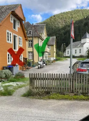 a house with a fence in front of a street at Rongahuset BnB in Evanger
