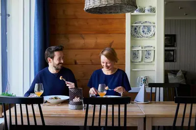a man and woman sitting at a table eating food at Heimly Pensjonat in Flåm
