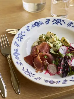 a plate of food with a salad on a table at Heimly Pensjonat in Flåm
