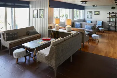 a living room with couches and a table and chairs at Heimly Pensjonat in Flåm