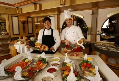 two chefs standing in a kitchen preparing food at Storefjell Resort in Gol