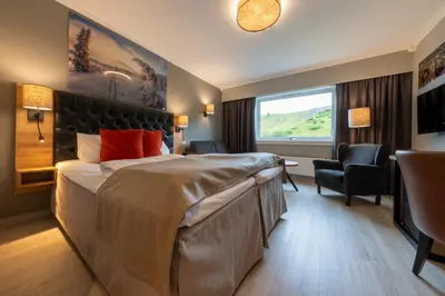 a hotel room with a large bed and a window at Storefjell Resort in Gol