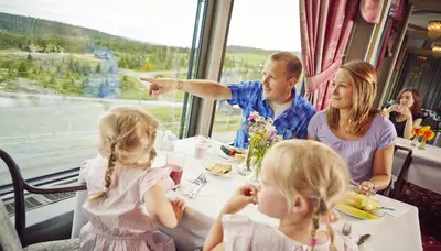 a group of people sitting at a table in a train at Storefjell Resort in Gol