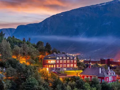 a large building in front of a mountain at Tyssedal Hotel in Tysso