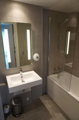 a bathroom with a sink and a shower and a mirror at Brakanes Hotel in Ulvik