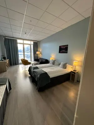 a hotel room with a large bed and a desk at Brakanes Hotel in Ulvik