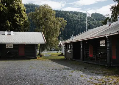two wooden buildings with a flag on top of them at Bårdshaug Herregård in Orkanger
