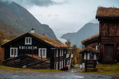 a group of buildings with mountains in the background at Røisheim Hotel & Skysstasjon in Lom