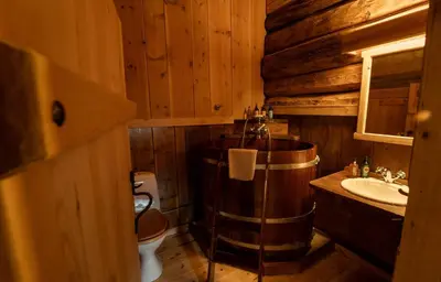 a wooden bathroom with a tub and a sink at Røisheim Hotel & Skysstasjon in Lom