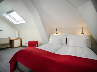 a bedroom with a red and white bed and a desk at Quality Hotel Grand Kristiansund in Kristiansund