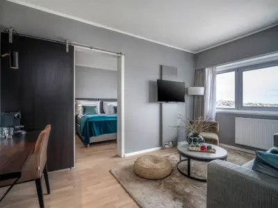 a living room with a room with a bed and a table at Quality Hotel Grand Kristiansund in Kristiansund