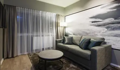a living room with a couch and a table at Quality Hotel Grand Kristiansund in Kristiansund