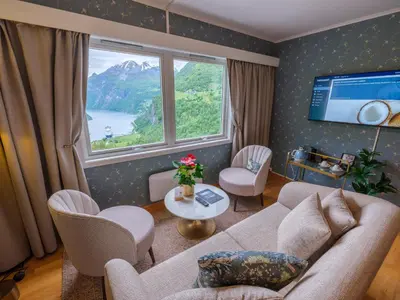 a living room with a couch and chairs and a large window at Hotel Utsikten - by Classic Norway Hotels in Geiranger