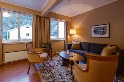a living room with a couch and a table at Hotel Utsikten - by Classic Norway Hotels in Geiranger