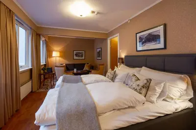 a bedroom with a large bed with white pillows at Hotel Utsikten - by Classic Norway Hotels in Geiranger