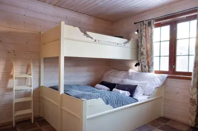a bedroom with bunk beds in a wooden cabin at Filefjellstuene hytter og leiligheter in Tyinkrysset