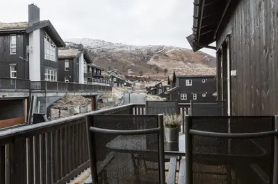 a balcony with chairs and a view of a town at Stranda Fjellgrend in Stranda