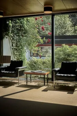 two chairs and a coffee table in front of a window at Energihotellet in Nesflaten