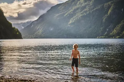 a young boy standing in a body of water at Energihotellet in Nesflaten