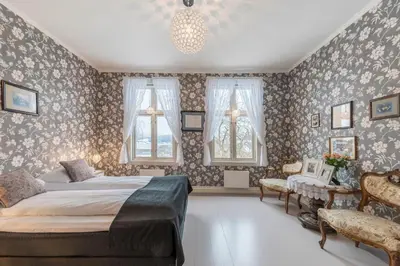 a bedroom with a large bed and floral wallpaper at Gloppen Hotell - by Classic Norway Hotels in Sandane