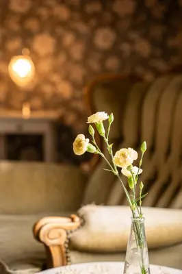 a vase with flowers sitting on a table at Gloppen Hotell - by Classic Norway Hotels in Sandane