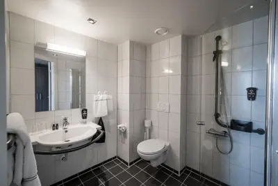 a bathroom with a toilet and a sink and a shower at Gloppen Hotell - by Classic Norway Hotels in Sandane