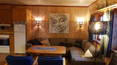 a living room with a couch and a table at Solbjørnlia Apartments in Trysil