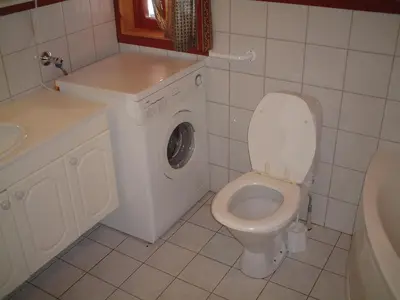 a bathroom with a washing machine and a toilet at Solbjørnlia Apartments in Trysil